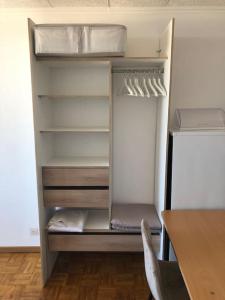 a refrigerator with its door open with a table and a chair at Studio met frontaal zeezicht in Ostend