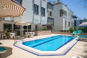 una piscina con tavolo e ombrellone accanto a un edificio di Enda Lara Hotel a Antalya (Adalia)