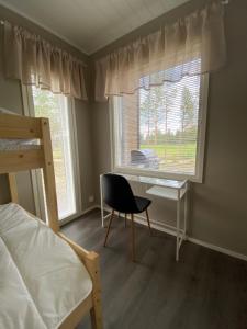 Schlafzimmer mit einem Schreibtisch, einem Bett und einem Fenster in der Unterkunft Sankivillat in Oulu