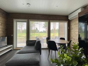 sala de estar con mesa, sillas y ventanas en Sankivillat, en Oulu