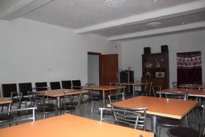 uma sala de aula vazia com mesas e cadeiras de madeira em HOTEL BODHGAYA INN em Bodh Gaya