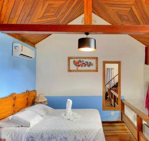 a bedroom with a bed in a room with wooden ceilings at Pousada Chalés do Lago in Visconde De Maua