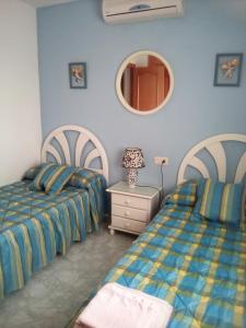 a bedroom with two beds and a mirror at CASA CARMEN in Calpe