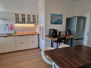 Una cocina con gabinetes blancos y una mesa y un refrigerador. en Tante Emma Dubai, en Kassel 15 fotos más