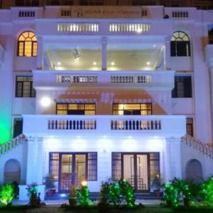 - un grand bâtiment blanc avec des lumières devant dans l'établissement IIDM ECO RESORT, à Lucknow