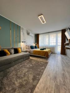 a large bedroom with a bed and a couch at AAB Studio Central in Piatra Neamţ