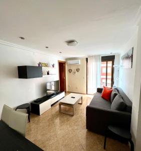 ein Wohnzimmer mit einem Sofa und einem Tisch in der Unterkunft Moderno apartamento en Valencia para 6 personas in Valencia