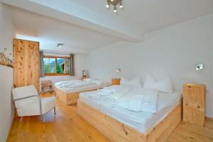 a large bedroom with two beds and a chair at Panorama Chalets Mauterndorf in Mauterndorf