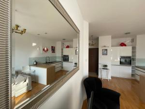 eine Küche und ein Wohnzimmer mit einem Spiegel an der Wand in der Unterkunft Wilanów Garden Apartment in Warschau