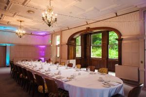 a large room with a long table and chairs at Makeney Hall Hotel in Derby