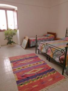 1 dormitorio con 2 camas y alfombra en Casa Angheledda, en Nulvi