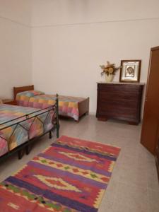 1 dormitorio con 2 camas, vestidor y alfombra en Casa Angheledda, en Nulvi