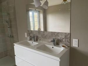 Baño con 2 lavabos y espejo en Domaine Au Fil du Temps en Ohey