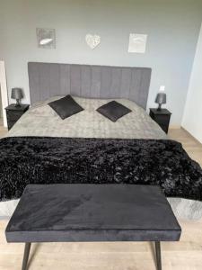 1 cama con edredón y almohadas en blanco y negro en Domaine Au Fil du Temps en Ohey