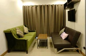 a living room with two chairs and a couch and a table at Gsuite Glamorous Apartment in Bangkok