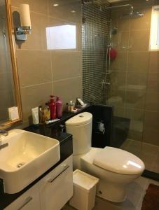 y baño con aseo, lavabo y ducha. en Gsuite Glamorous Apartment, en Bangkok