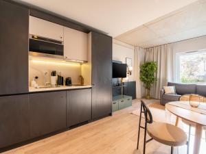 een keuken en een woonkamer met een tafel en een bank bij limehome Düsseldorf Stresemannstraße - Digital Access in Düsseldorf