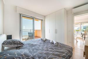 a bedroom with a bed with a view of the ocean at Baie Roquebrune, Vue Mer, Parking Gratuit - AJ in Roquebrune-Cap-Martin