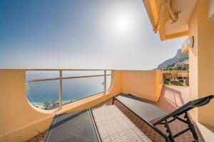 a balcony with a chair and a view of the ocean at Baie Roquebrune, Vue Mer, Parking Gratuit - AJ in Roquebrune-Cap-Martin