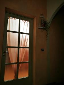 una puerta que conduce a una ventana con una cortina en Cà del Teatro, en Valenza