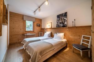 dwa łóżka w pokoju z drewnianymi ścianami w obiekcie Apartment Valvisons Les Houches Chamonix - by EMERALD STAY w mieście Les Houches