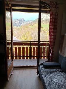 a room with a bed and a balcony with a view at la dryade chinaillon in Le Grand-Bornand