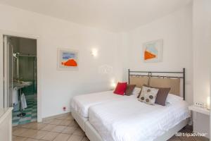 a bedroom with a large white bed and a bathroom at La Reginella Capri in Capri