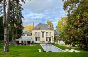 an exterior view of a large house with a pond in the yard at Manoir François du Tilleul - Reims - Fismes in Fismes