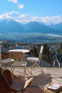 stół i krzesła na balkonie z widokiem na góry w obiekcie Vue de carte postale en hypercentre de Font-Romeu w mieście Font-Romeu-Odeillo-Via