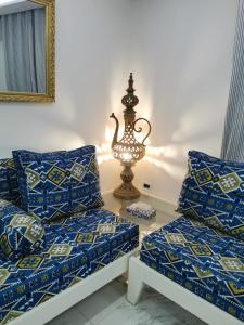 a room with two beds and a lamp on a table at Écrin in Sousse