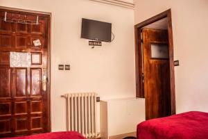 ein Zimmer mit einer Tür und einem Fernseher an der Wand in der Unterkunft Hôtel Restaurant Ali in Midelt