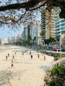un grupo de personas jugando al voleibol en una playa en Apto Frente ao Mar Asturias, en Guarujá