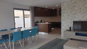 Una cocina y un comedor con una mesa y sillas azules. en Villa Silver Coast, en Nadadouro