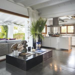 a living room with a table and a kitchen at Impressive Ibiza Villa El Zafiro 6 Bedrooms Private Gym & Views in Sant Josep de Sa Talaia