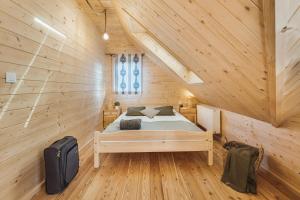 a bedroom with a bed in a wooden cabin at Pienińska Przystań in Kluszkowce