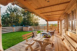 una terrazza in legno con tavolo e cesto di frutta. di Pienińska Przystań a Kluszkowce