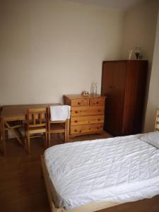 a bedroom with a bed and a table and a dresser at George Lane in London