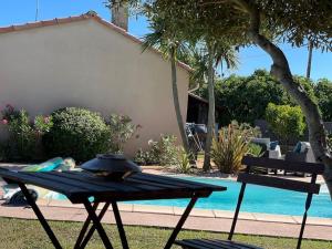 a picnic table next to a swimming pool at Ôverger, studio cosy, aux portes de Toulouse in Belberaud
