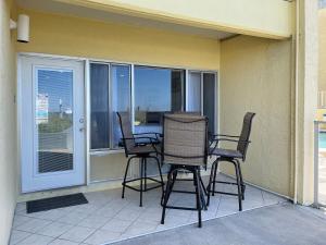 un patio con 3 sillas y una mesa en el balcón en Continental 316 en Panama City Beach