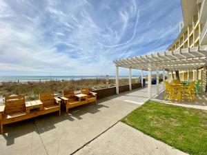 un patio con mesas y sillas junto a la playa en Continental 316 en Panama City Beach