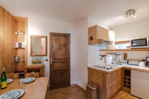 a kitchen with a wooden table and a wooden door at Paradis in Chamonix