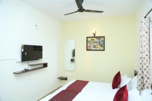a bedroom with a bed and a flat screen tv at Bangalore Airport Inn Hotel, Near Kempegowda Airport in Bangalore