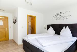 a bedroom with a large bed with white sheets at Haus Mayerhofer in Sankt Gilgen