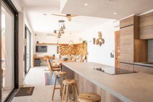 a kitchen and living room with a counter and stools at beachhouse MIMA in Saly Portudal