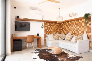 uma sala de estar com um sofá branco e uma televisão em beachhouse MIMA em Saly Portudal