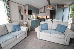 ein Wohnzimmer mit 2 Sofas und einer Küche in der Unterkunft Stunning Caravan With Wifi At Azure Seas Nearby The Beautiful Beach Ref 32057az in Lowestoft