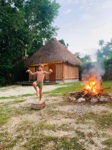 a young boy standing in front of a fire at Tulum Nueve in Tulum