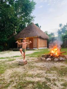 un joven parado frente al fuego en Tulum Nueve, en Tulum