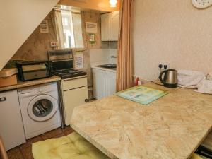 a small kitchen with a counter with a washer and dryer at Low Skibeden Cottage in Skipton