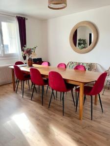 jadalnia z drewnianym stołem i czerwonymi krzesłami w obiekcie Vive la vie - maison de famille à Mers proche mer w mieście Mers-les-Bains